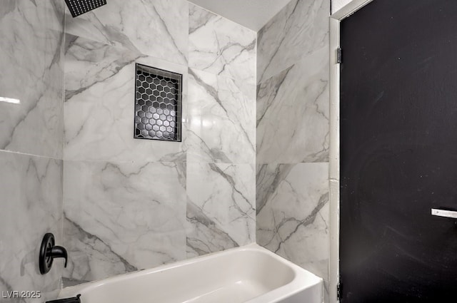 bathroom featuring tiled shower / bath