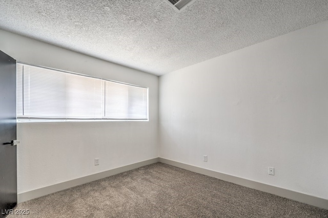 carpeted spare room featuring a textured ceiling