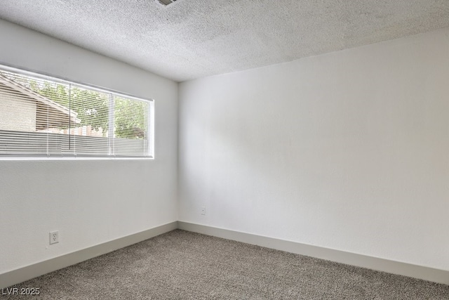 spare room featuring carpet floors and a textured ceiling