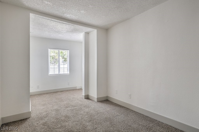 empty room with a textured ceiling and carpet floors