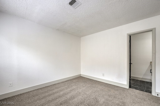 unfurnished room with dark colored carpet and a textured ceiling