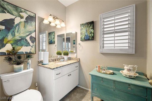 bathroom with vanity, toilet, a wealth of natural light, and tile patterned floors