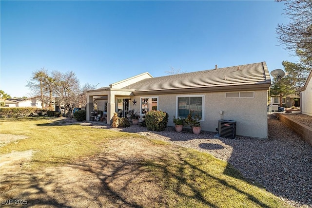 rear view of property with a lawn and central air condition unit