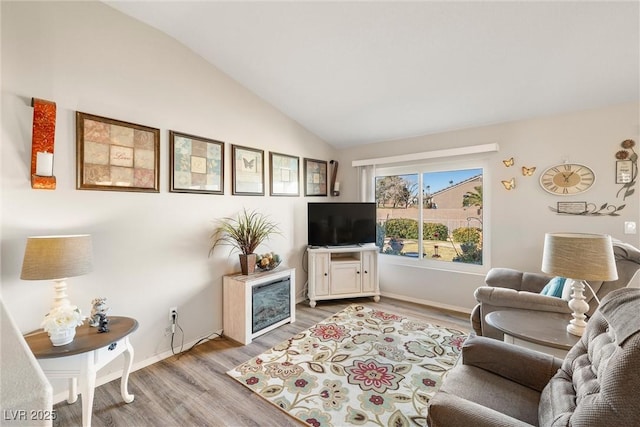 living room with light hardwood / wood-style flooring and vaulted ceiling