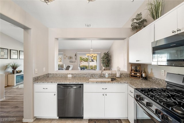 kitchen featuring sink, white cabinets, stainless steel appliances, and lofted ceiling