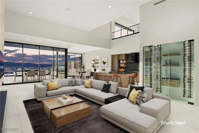 living room with a high ceiling and light tile patterned floors