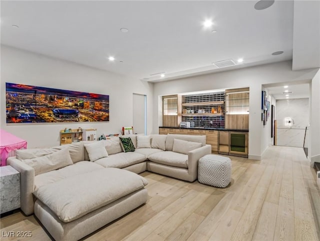 living room with wine cooler and light hardwood / wood-style flooring