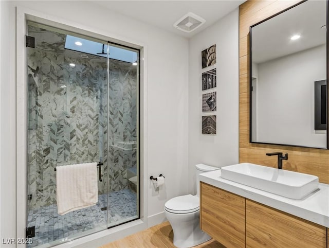 bathroom featuring walk in shower, vanity, and toilet