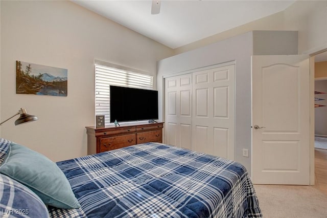 bedroom with a closet, ceiling fan, vaulted ceiling, and light carpet