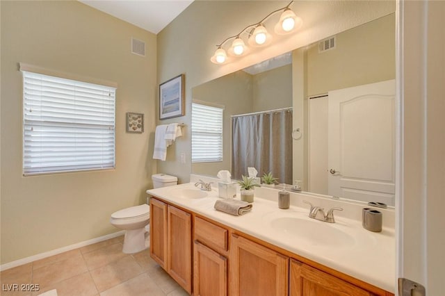 bathroom with tile patterned floors, vanity, toilet, and walk in shower