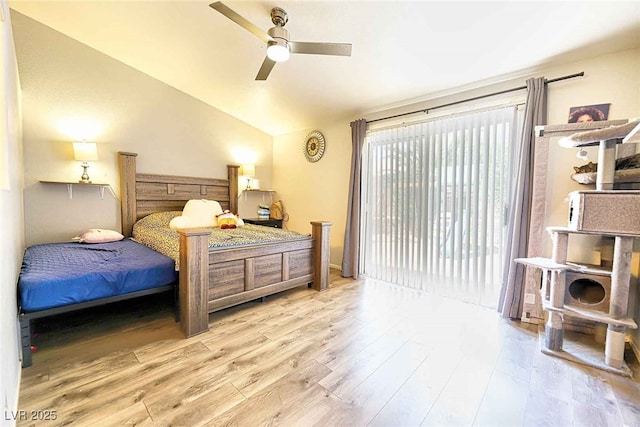 bedroom featuring ceiling fan, light hardwood / wood-style flooring, and lofted ceiling