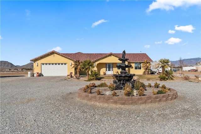 view of front of home with a garage and a mountain view