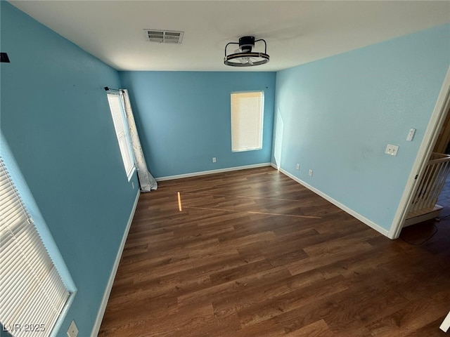 unfurnished room with dark wood-type flooring