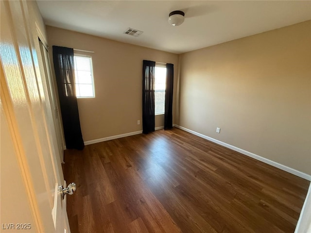 unfurnished room with dark hardwood / wood-style floors and a healthy amount of sunlight