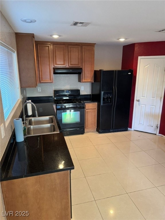 kitchen with sink, light tile patterned floors, and black appliances