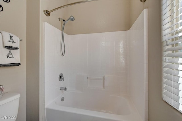 bathroom featuring tub / shower combination and toilet