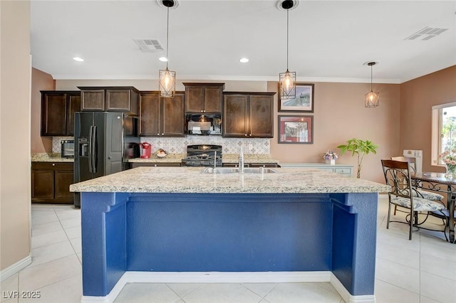 kitchen with black appliances, a kitchen island with sink, and hanging light fixtures