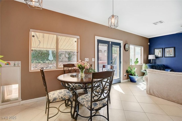 dining room featuring crown molding and light tile patterned floors