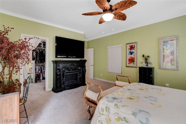 bedroom featuring crown molding, a walk in closet, light carpet, a closet, and ceiling fan