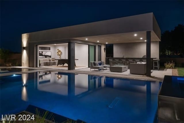 pool at twilight featuring an outdoor living space, a jacuzzi, and a patio