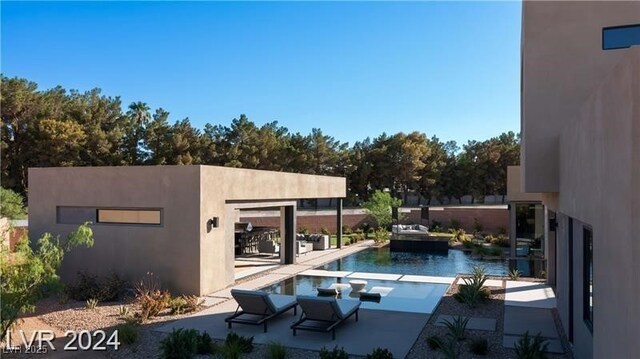 view of swimming pool featuring a patio and a water view