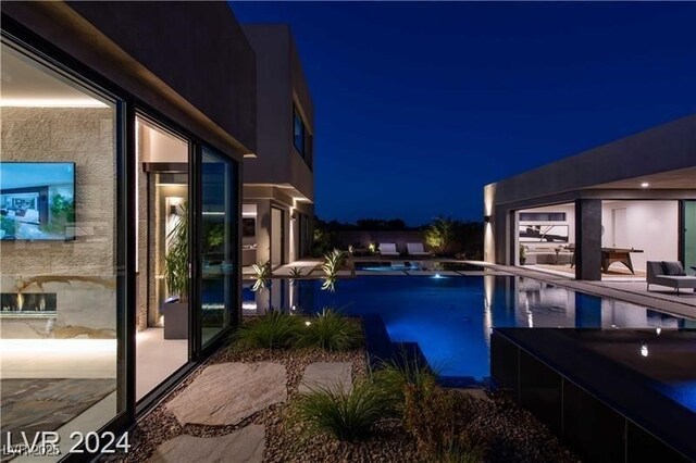 view of pool at twilight