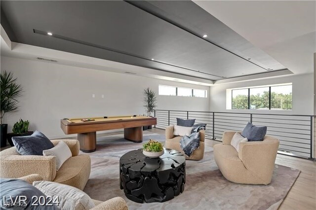 recreation room with a tray ceiling, light hardwood / wood-style flooring, and pool table