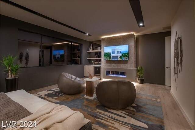 living room with built in shelves, hardwood / wood-style flooring, and a fireplace