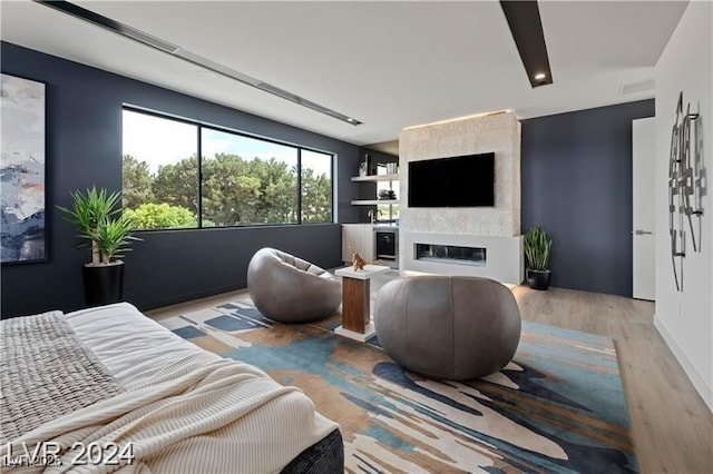 living room with a large fireplace and light hardwood / wood-style floors