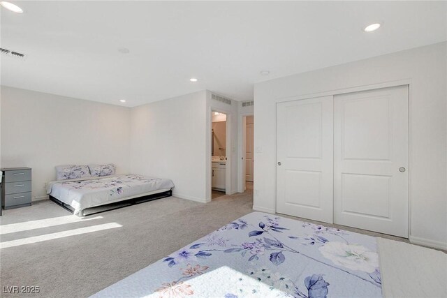 carpeted bedroom featuring ensuite bathroom and a closet