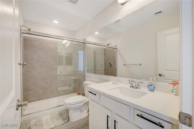 bathroom with a shower with door, toilet, tile patterned floors, and vanity