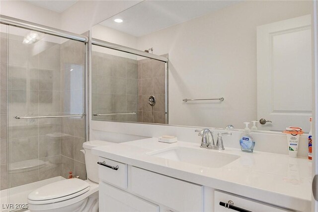 bathroom featuring toilet, vanity, and walk in shower