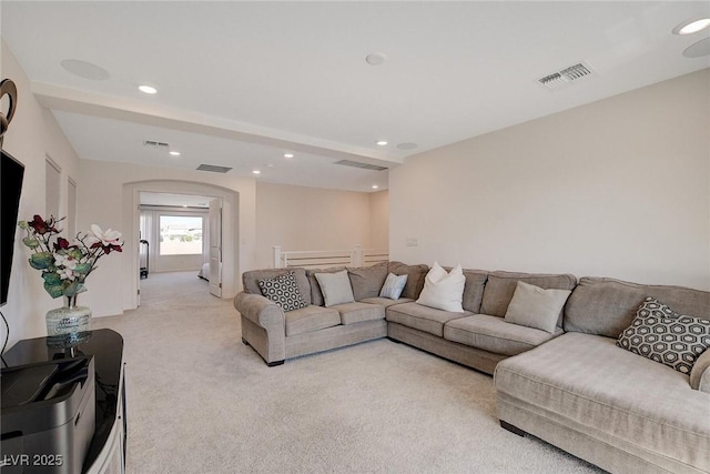 carpeted living room featuring beamed ceiling