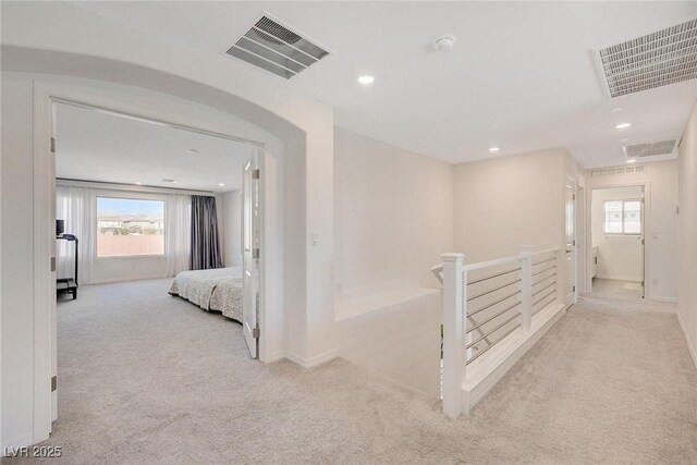 hallway featuring light colored carpet