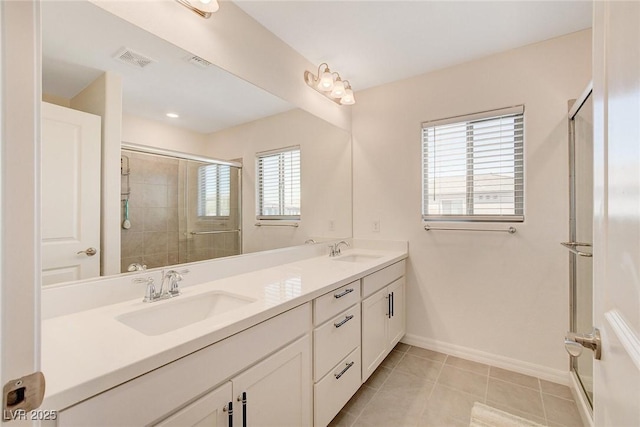 bathroom with a shower with door, tile patterned floors, and vanity