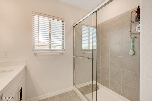 bathroom with vanity, a wealth of natural light, a shower with door, and tile patterned flooring