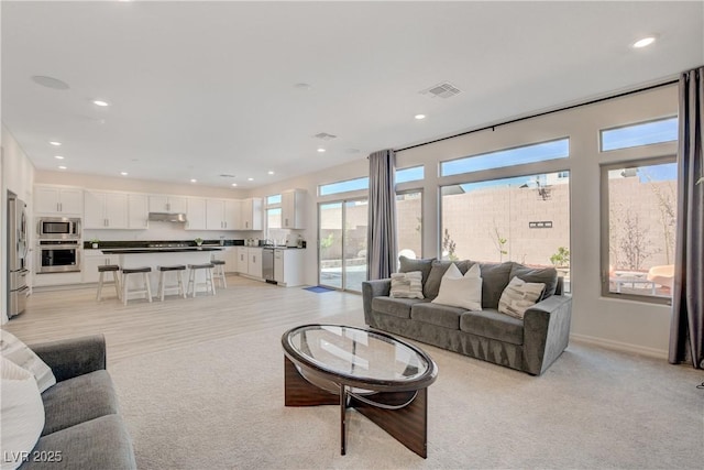 living area with light colored carpet, baseboards, visible vents, and recessed lighting