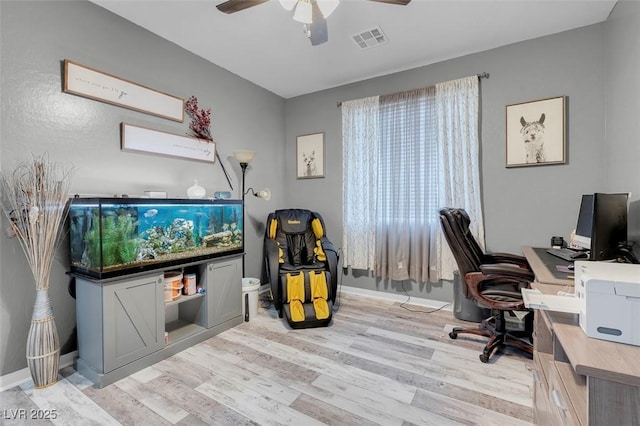 home office with light hardwood / wood-style floors and ceiling fan