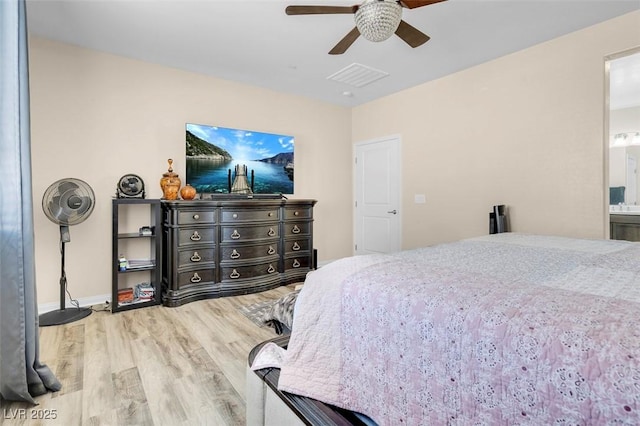 bedroom with ceiling fan, hardwood / wood-style floors, and ensuite bath