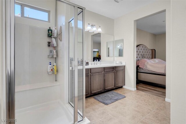 bathroom with a shower with shower door, tile patterned floors, and vanity