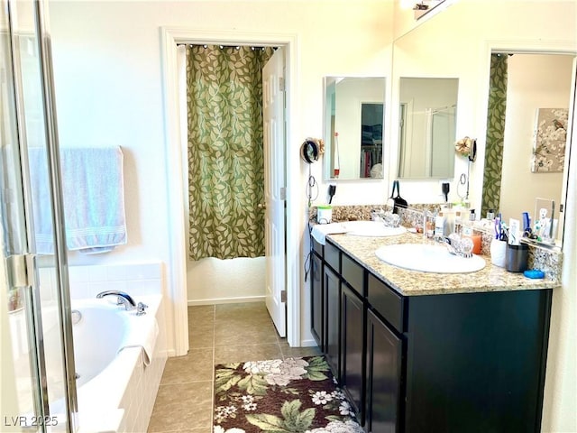 bathroom with tiled tub, tile patterned floors, and vanity