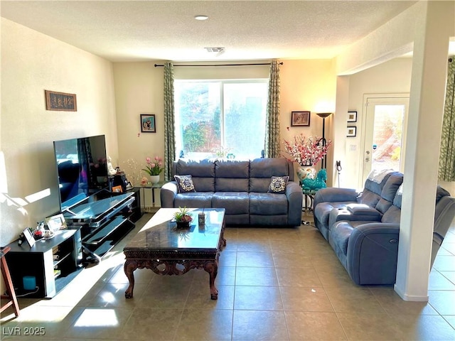 tiled living room featuring a textured ceiling