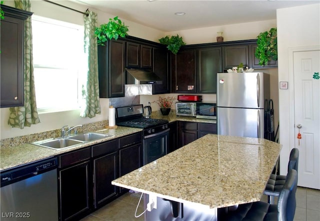 kitchen with sink, stainless steel appliances, a center island, and a breakfast bar area