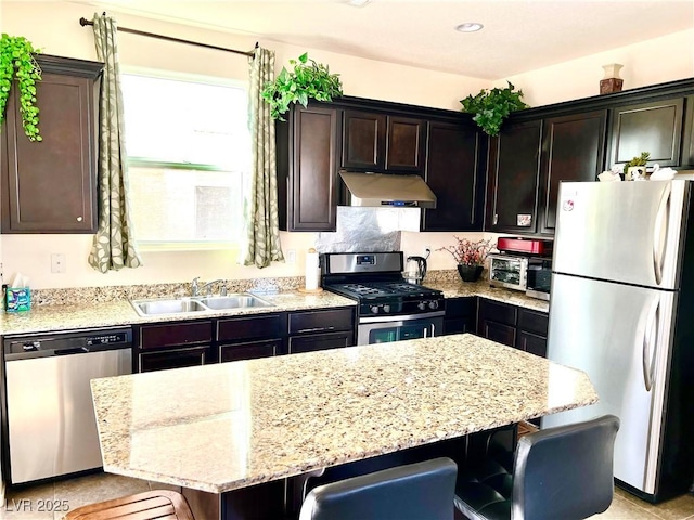 kitchen featuring a breakfast bar, appliances with stainless steel finishes, sink, and dark brown cabinets