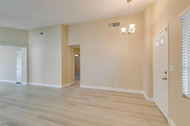 unfurnished room featuring light hardwood / wood-style floors and a notable chandelier