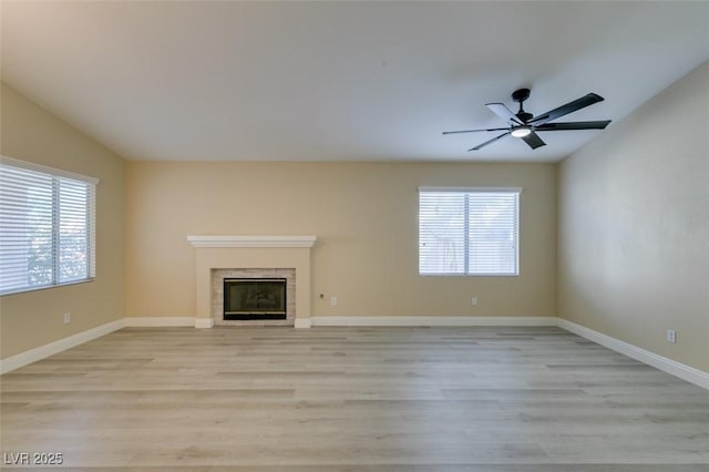 unfurnished living room with light hardwood / wood-style floors, lofted ceiling, and a healthy amount of sunlight