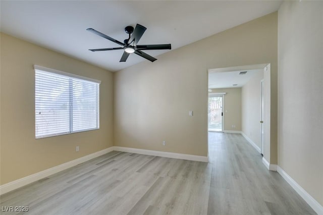 spare room with ceiling fan, light wood-type flooring, and vaulted ceiling