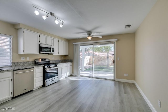 kitchen with light stone counters, white cabinetry, appliances with stainless steel finishes, and light hardwood / wood-style flooring