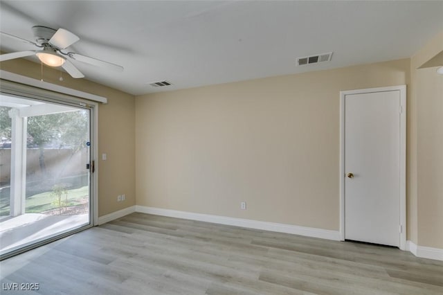 spare room featuring ceiling fan, light wood-type flooring, and a healthy amount of sunlight