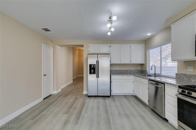 kitchen featuring light stone countertops, sink, white cabinets, and appliances with stainless steel finishes